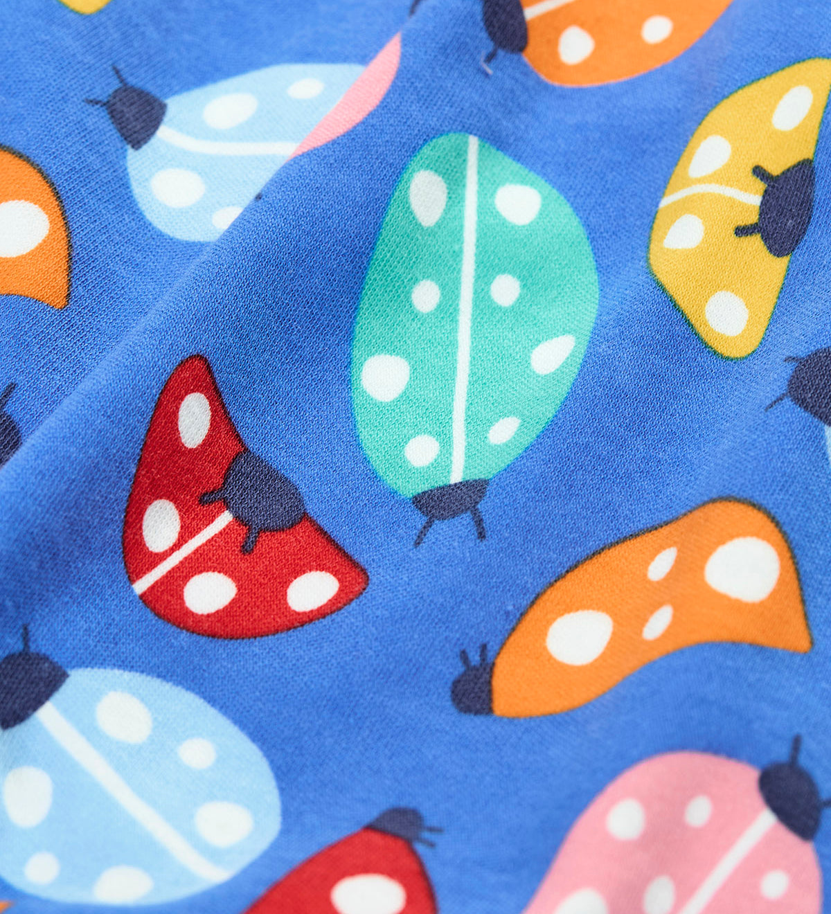 A close up of the repeated ladybird print on the Frugi parsnip pants