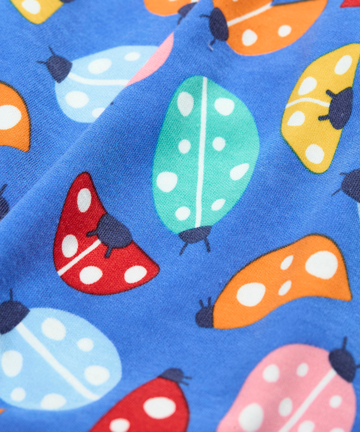 A close up of the repeated ladybird print on the Frugi parsnip pants