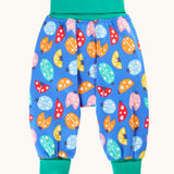Frugi organic cotton parsnip pants laid flat in light blue and turquoise trim with a repeated ladybird print