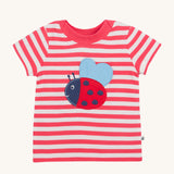 Frugi pink stripe short sleeve top ladybird design on a cream background.