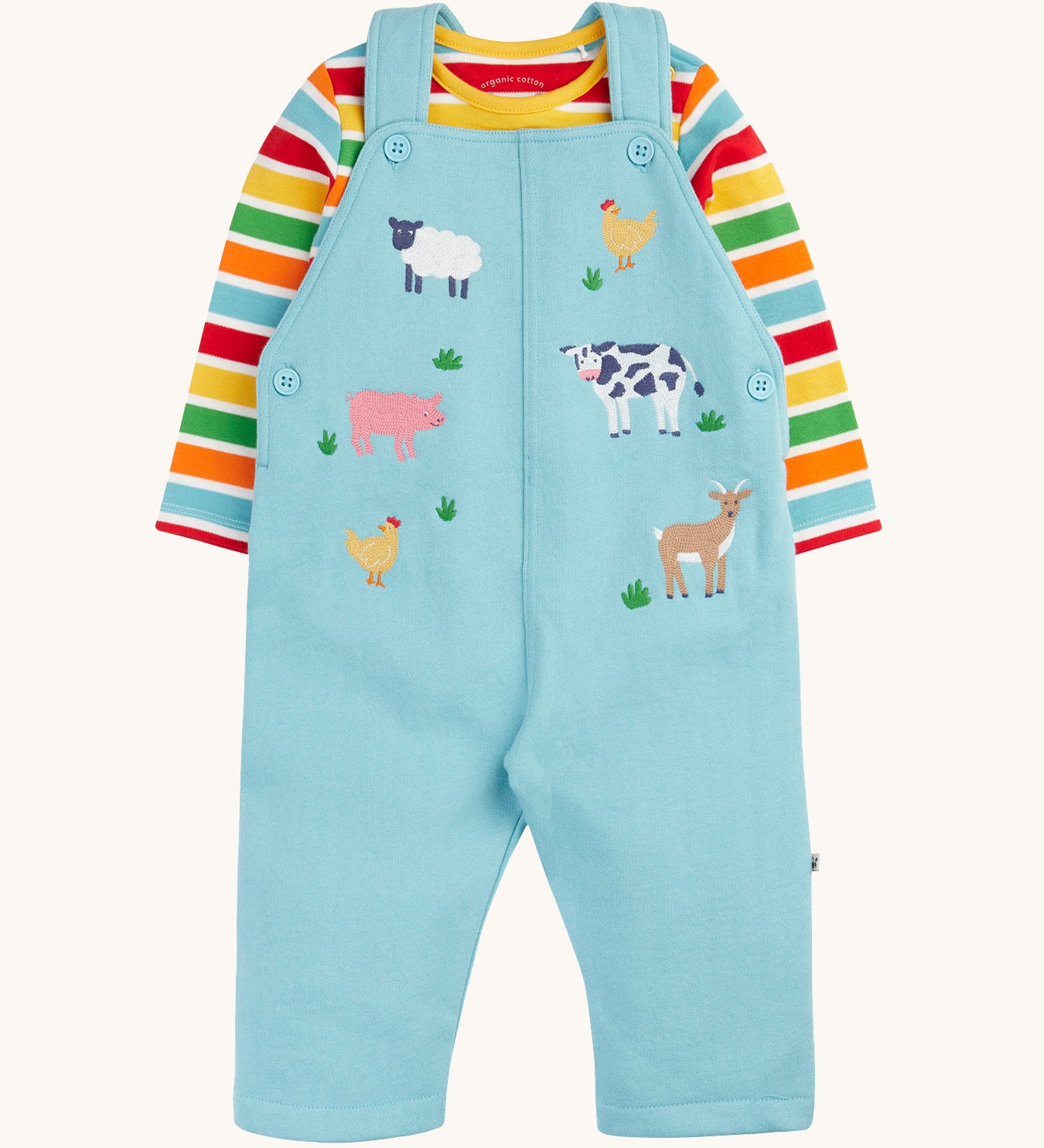 Frugi light blue organic cotton dungaree with farm animals on the front with a rainbow striped long sleeve top underneath as an outfit