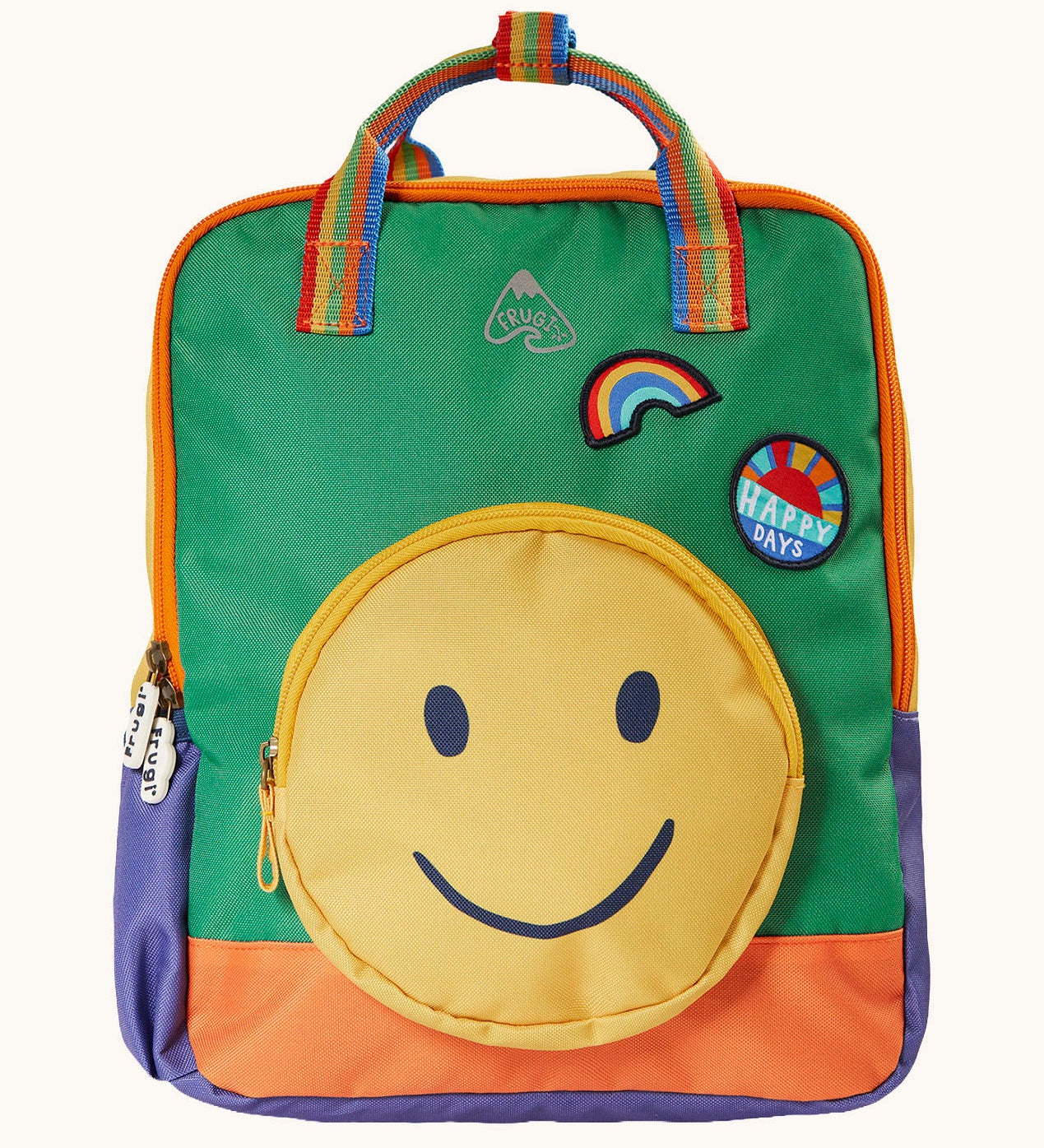 Frugi backpack standing upright. A green and orange block coloured backpack with a smiley face as a front pocket. Features a rainbow handle and patches. 