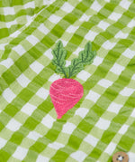 Close up of the Frugi Reggie kids shirt. showing the beetroot embroidery detail on green gingham organic cotton fabric