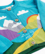 A close up of the Frugi kid reva knitted cardigan in blue/mountain scene showing the mountain scene detail and button  fasteners. 