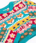 A close up of the Frugi kids robyn fairisle cardigan in fox showing the button detail and bright blue trim detail on organic cotton fabric.