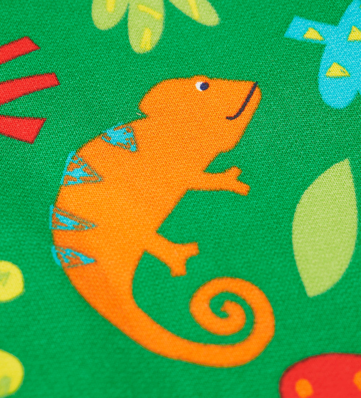 A close up of the orange chameleon design on the Frugi green samson printed shorts
