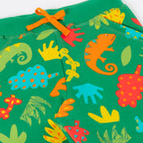 A close up of the orange waist tie and the repeated chameleon and leaves design on the Frugi green samson shorts