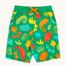 Frugi samson printed shorts laid flat. In bright green with a repeated chameleon and leaves print. Features a orange waist tie
