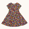 Frugi organic cotton skater dress laid flat. In navy with a repeating heart, sun rainbow and flower print.