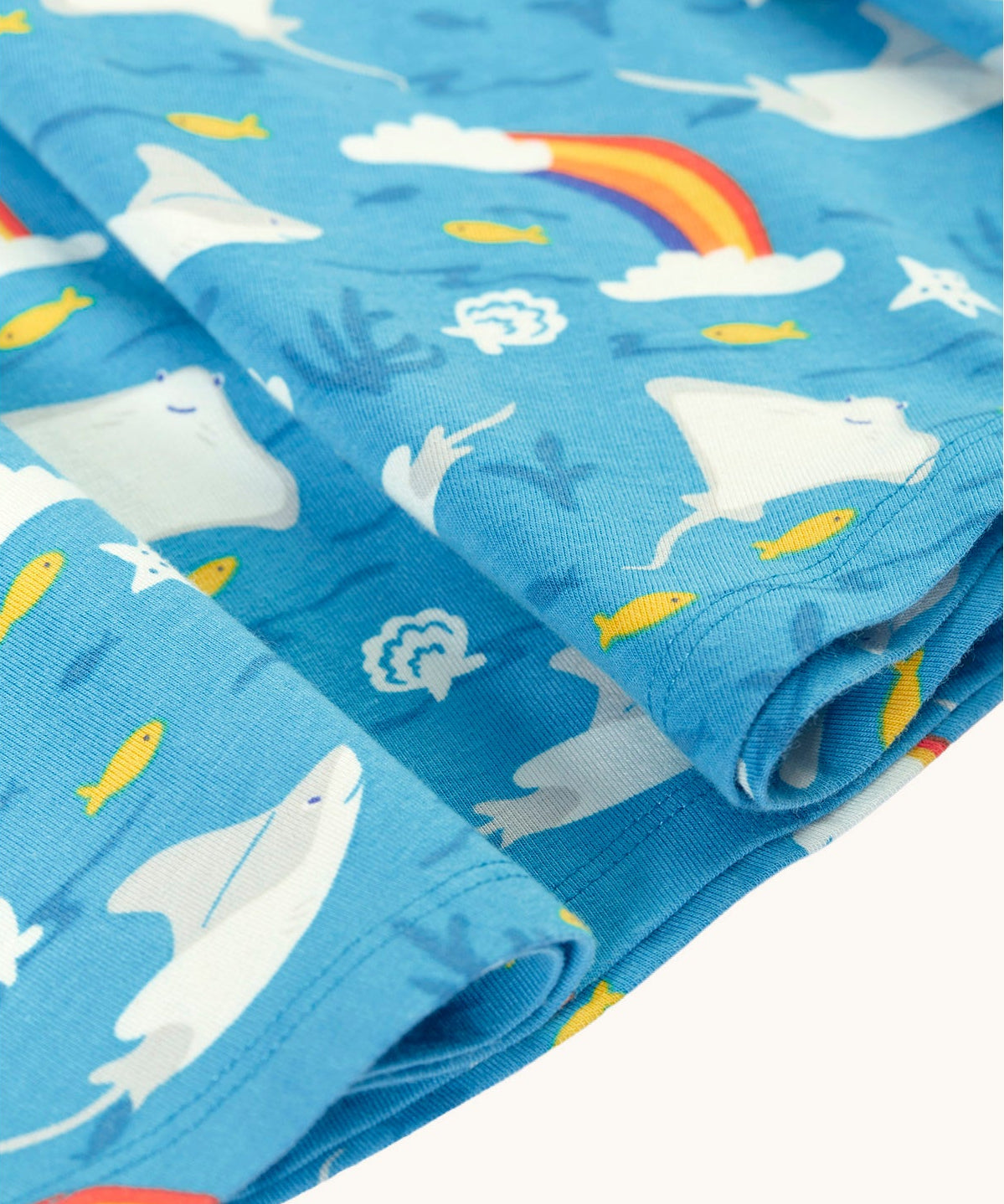 A close up of the light blue manta ray Frugi skater dress laid flat showing the frill detail 