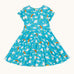 Frugi organic cotton skater dress laid flat. In light blue with a repeating grey manta ray and rainbow print