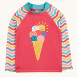 Frugi recycled plastic rash vest laid flat. In light pink with a pastel wavy striped design on the long sleeves and a playful ice cream design on the front
