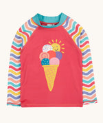 Frugi recycled plastic rash vest laid flat. In light pink with a pastel wavy striped design on the long sleeves and a playful ice cream design on the front