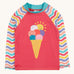 Frugi recycled plastic rash vest laid flat. In light pink with a pastel wavy striped design on the long sleeves and a playful ice cream design on the front