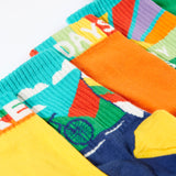 A close up of the Frugi adventure themed multipack socks laid flat. In different colours and designs with a elasticated cuff