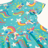 A close up of the turquoise skater dress laid flat showing the repeating roller blades and skateboard prints with colourful shapes.