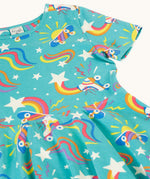 A close up of the turquoise skater dress laid flat showing the repeating roller blades and skateboard prints with colourful shapes.