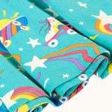 A close up of the turquoise skater dress laid flat showing the repeating roller blades and skateboard prints and frill detail