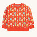 Frugi organic cotton sweatshirt laid flat. In red with a repeating pastel coloured flower print.