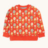 Frugi organic cotton sweatshirt laid flat. In red with a repeating pastel coloured flower print.