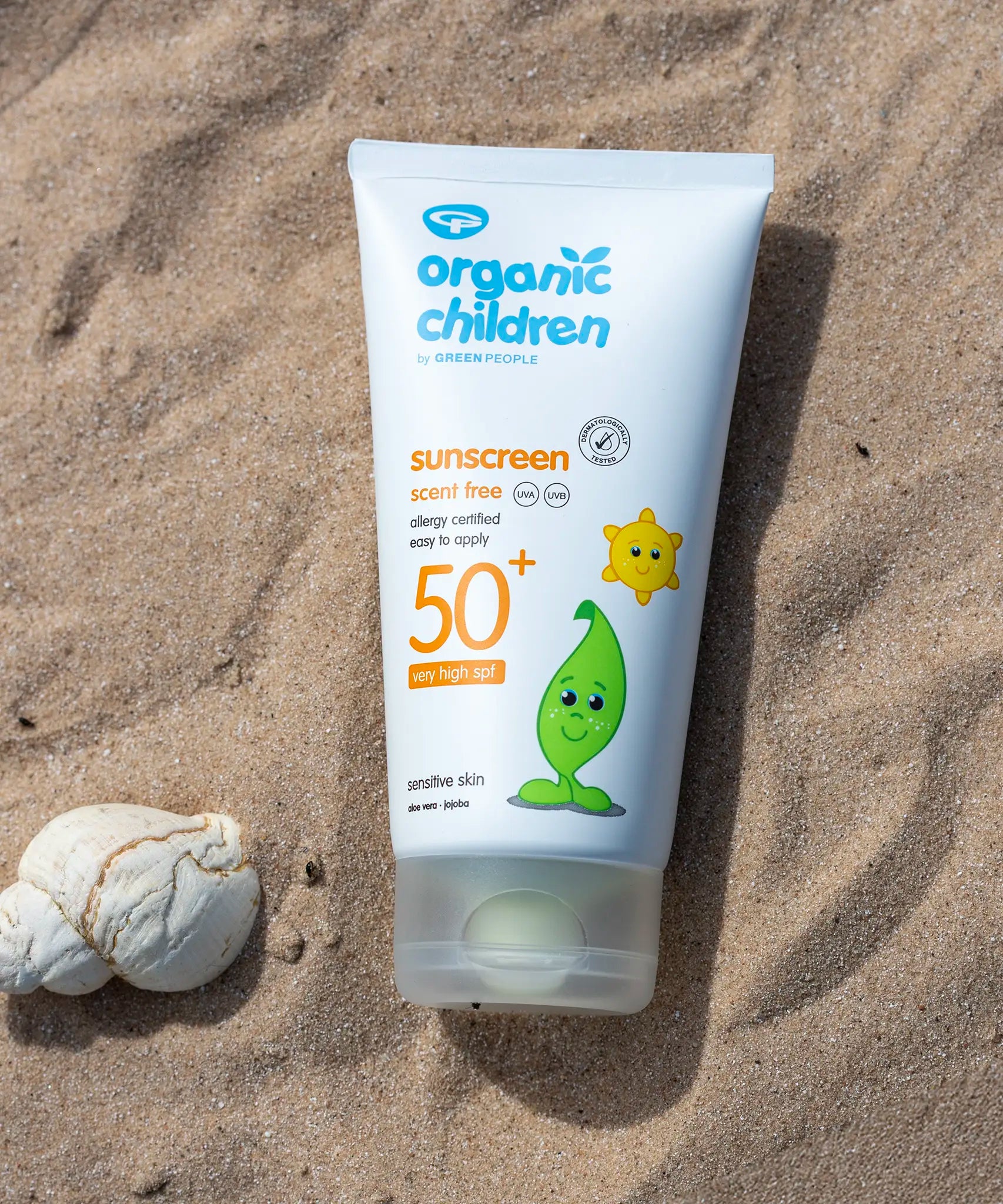 Green People organic children SPF50 scent free sun cream lying flat on sand next to a shell