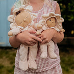A child holding the Olli Ella Limited Edition Blossom Buds Gift Set - Gardenia, showing the Tootsie Gardenia & Dinky Dinkum Doll - Gracie Gardenia in their arms