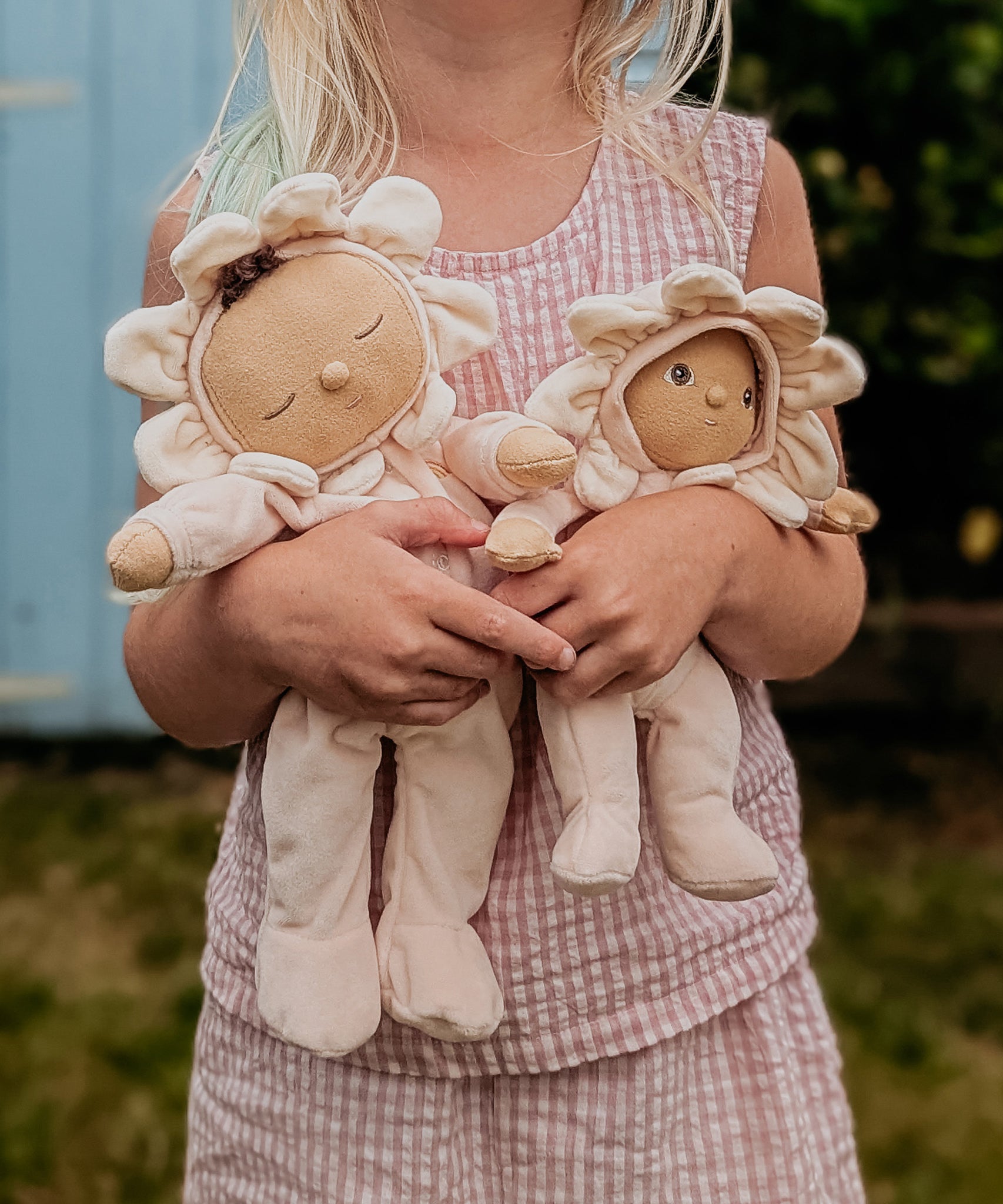 A child holding the Olli Ella Limited Edition Blossom Buds Gift Set - Gardenia, showing the Tootsie Gardenia & Dinky Dinkum Doll - Gracie Gardenia in their arms