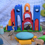 Gluckskafer blue castle in a play setup on a wooden surface. Features wooden animal figures
