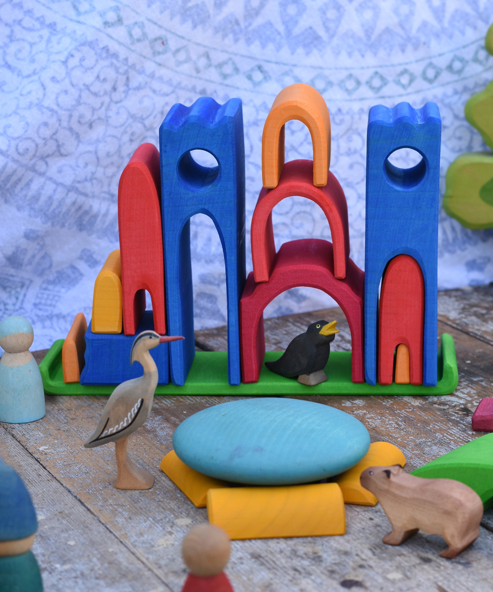 Gluckskafer blue castle in a play setup on a wooden surface. Features wooden animal figures