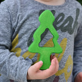 Child holding one of teh middle pieces from the Glückskäfer 6-Piece Fir Tree wooden tree stacking toy in his hans.