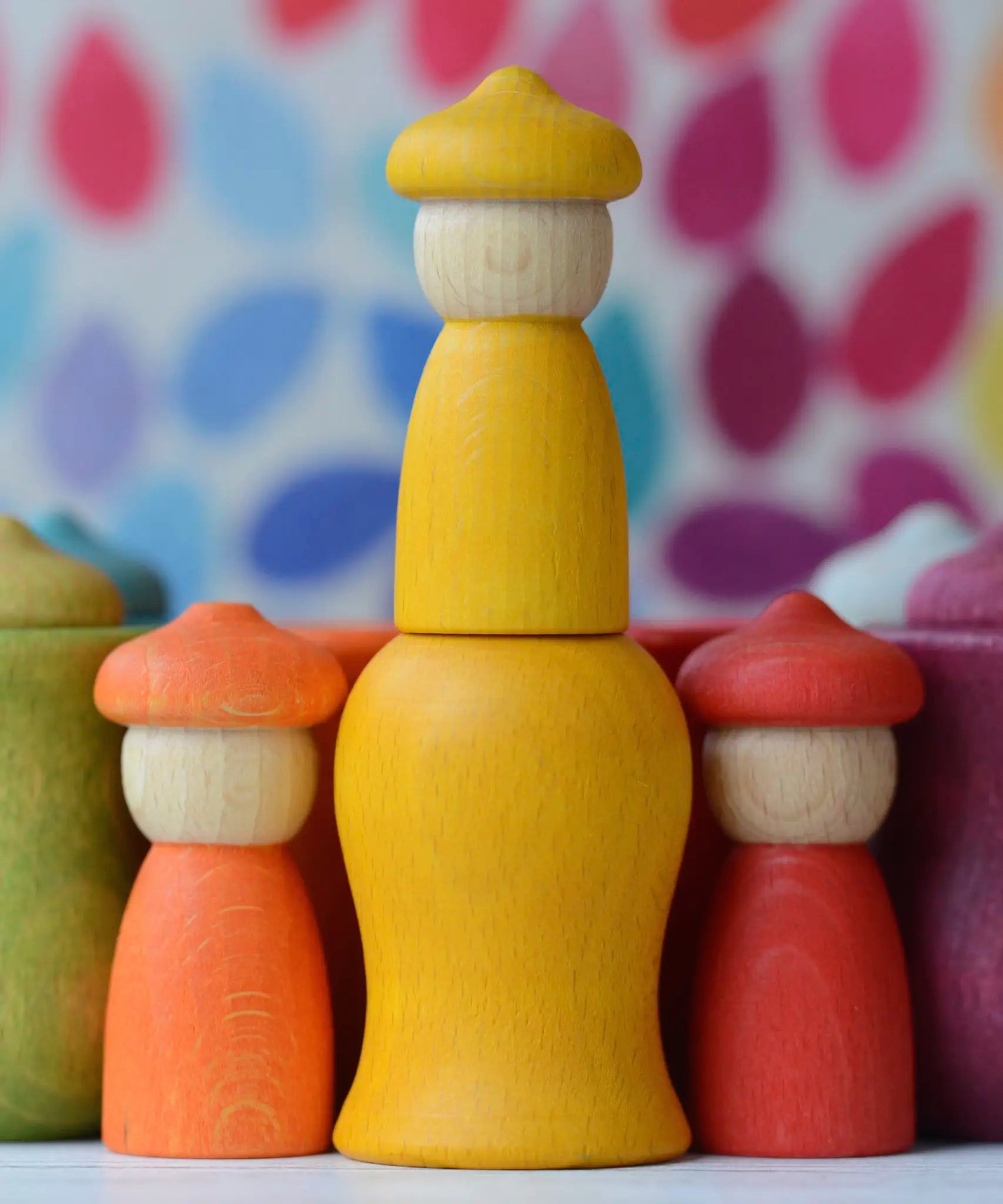 Handcrafted yellow Grapat wooden peg doll standing on a matching curved cup from the 7 moons weekly calendar set