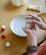 A closer look at the child making a wool ball craft activity, from the Grapat Advent Calendar 2024