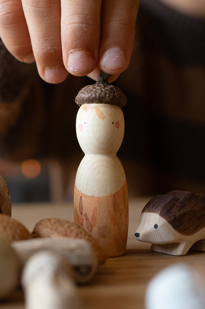A child holding a wooden peg doll Nin from the Grapat x Ostheimer Hello Autumn play set - to represent new Grapat 2025 at Babipur.