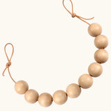 Grapat handcrafted garland. A sensory toy showing 10 natural wooden balls on a rope