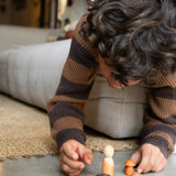 A child playing with the different wooden pieces and figures from the Grapat / Ostheimer hello Autumn wooden set available at Babipur. 