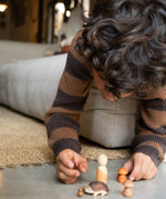 A child playing with the different wooden pieces and figures from the Grapat / Ostheimer hello Autumn wooden set available at Babipur. 