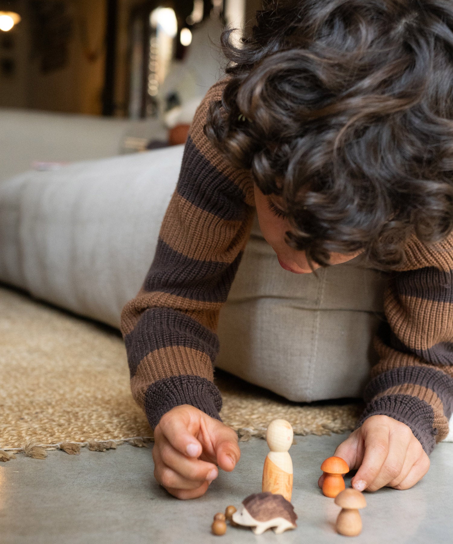 A child playing with the different wooden pieces and figures from the Grapat / Ostheimer hello Autumn wooden set available at Babipur. 
