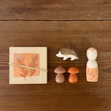 A top down image of the Grapat / Ostheimer hello Autumn wooden set available at Babipur. Each handmade and hand painted wooden piece is displayed on a wooden surface