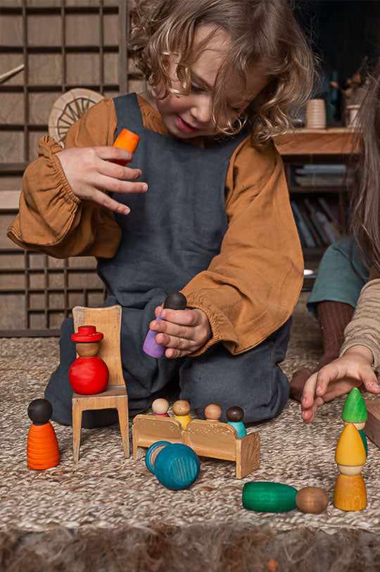 Child playing with Grapat together set - wooden peg dolls in different shapes, colours and wood - to represent Grapat Toys at Babipur, official UK stockist. 