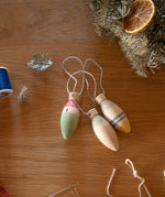 Grapat Handmade and handpainted Wooden winter sparkle decorations available at Babipur on a wooden table