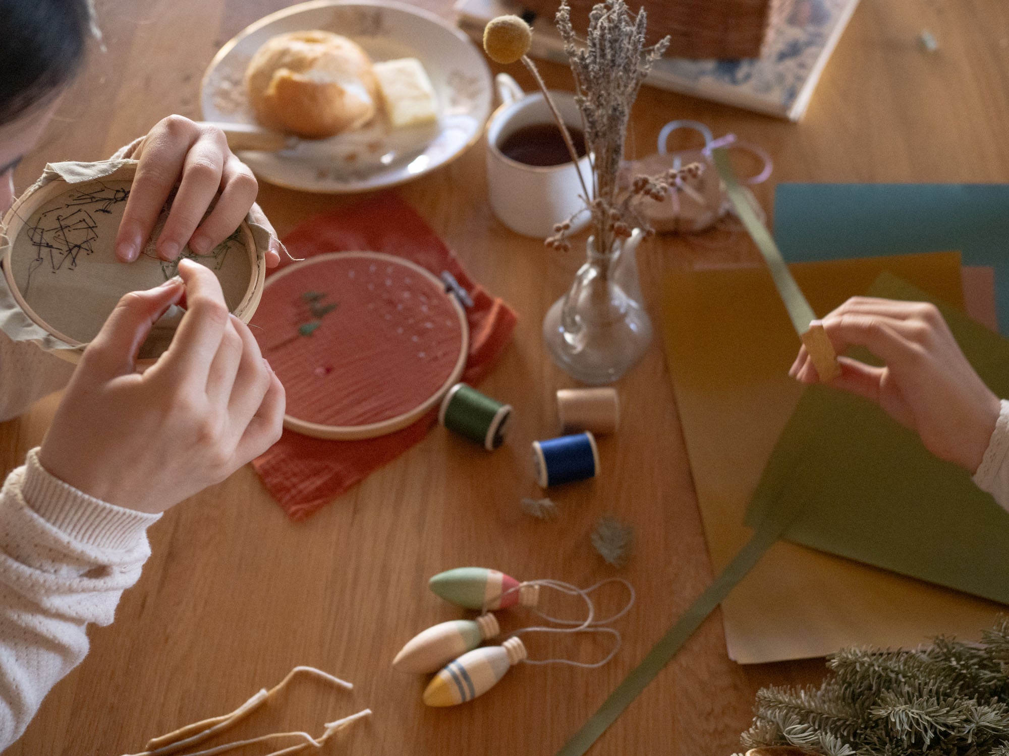 Grapat Handmade and handpainted Wooden winter sparkle decorations available at Babipur on a wooden table with 2 children making festive crafts.