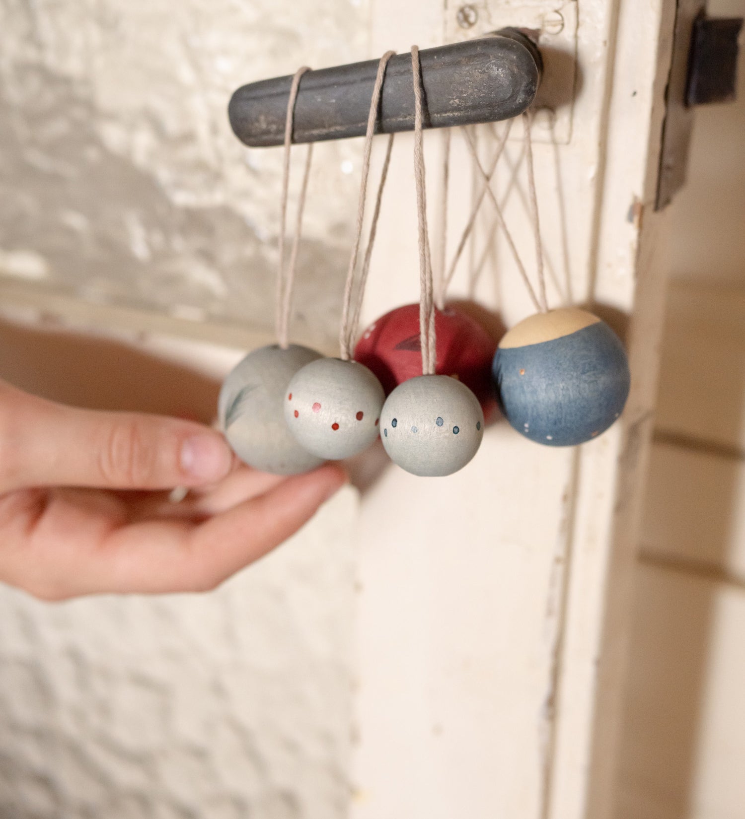 A set of 5 Grapat winter handmade and hand painted wish balls hanging from a door handle