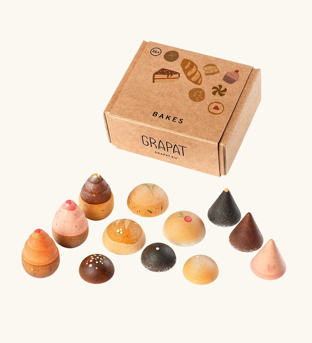 Grapat bakes set showing different hand crafted wooden cake pieces standing next to a decorated cardboard box