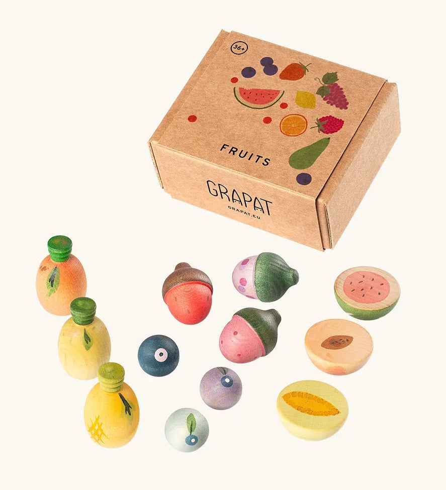 Grapat fruit set showing different hand crafted wooden fruit pieces standing next to a decorated cardboard box