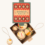 A opened teal and coral cardboard box for the wooden Grapat wonder balls on a cream background