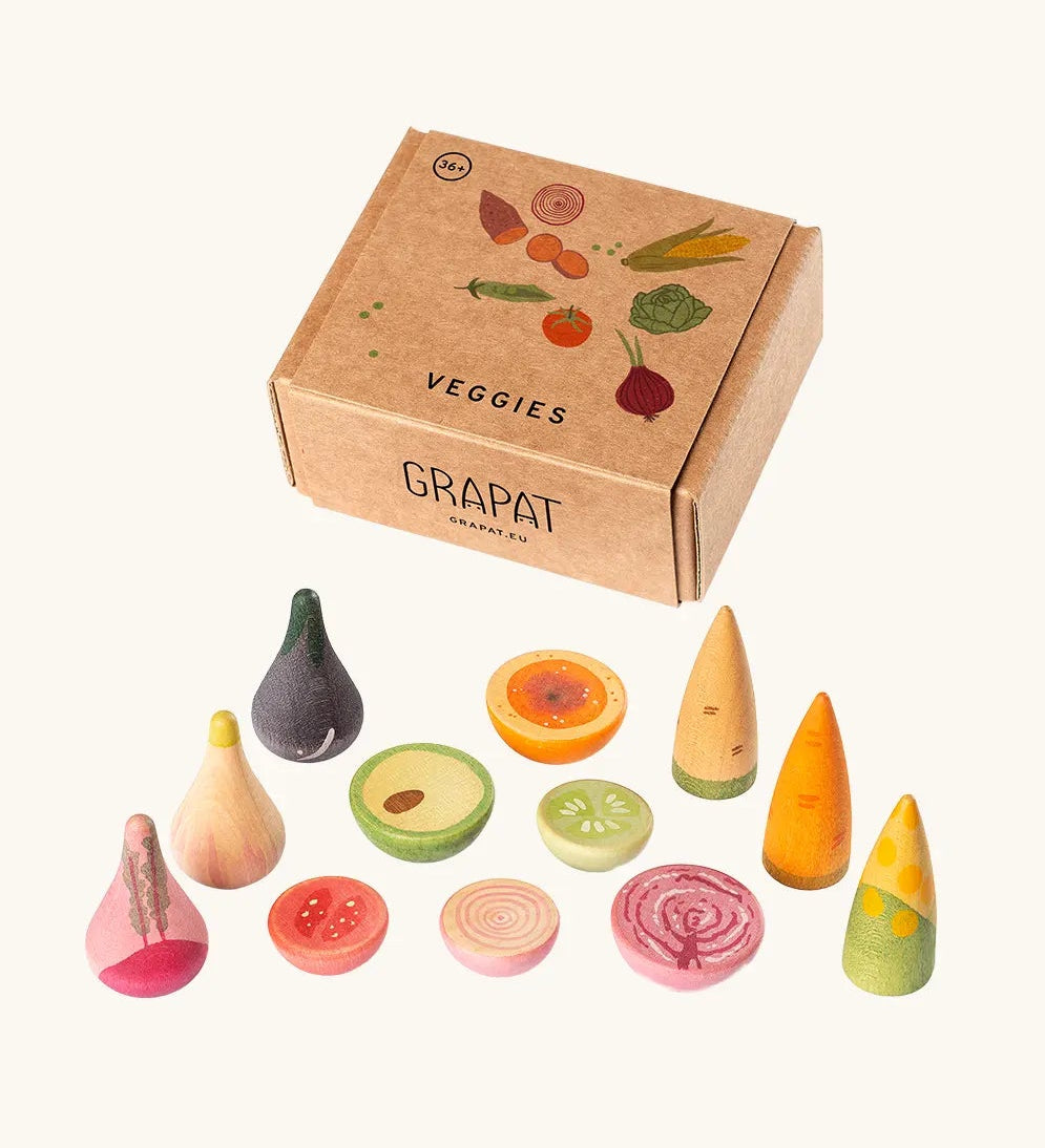 Grapat wooden veggie set showing different hand crafted and hand painted veg pieces standing next to a decorated cardboard box