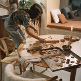 2 children baking festive cookies in a kitchen setting with Grapat wooden peg doll pieces from the Grapat advent calendar available at Babipur