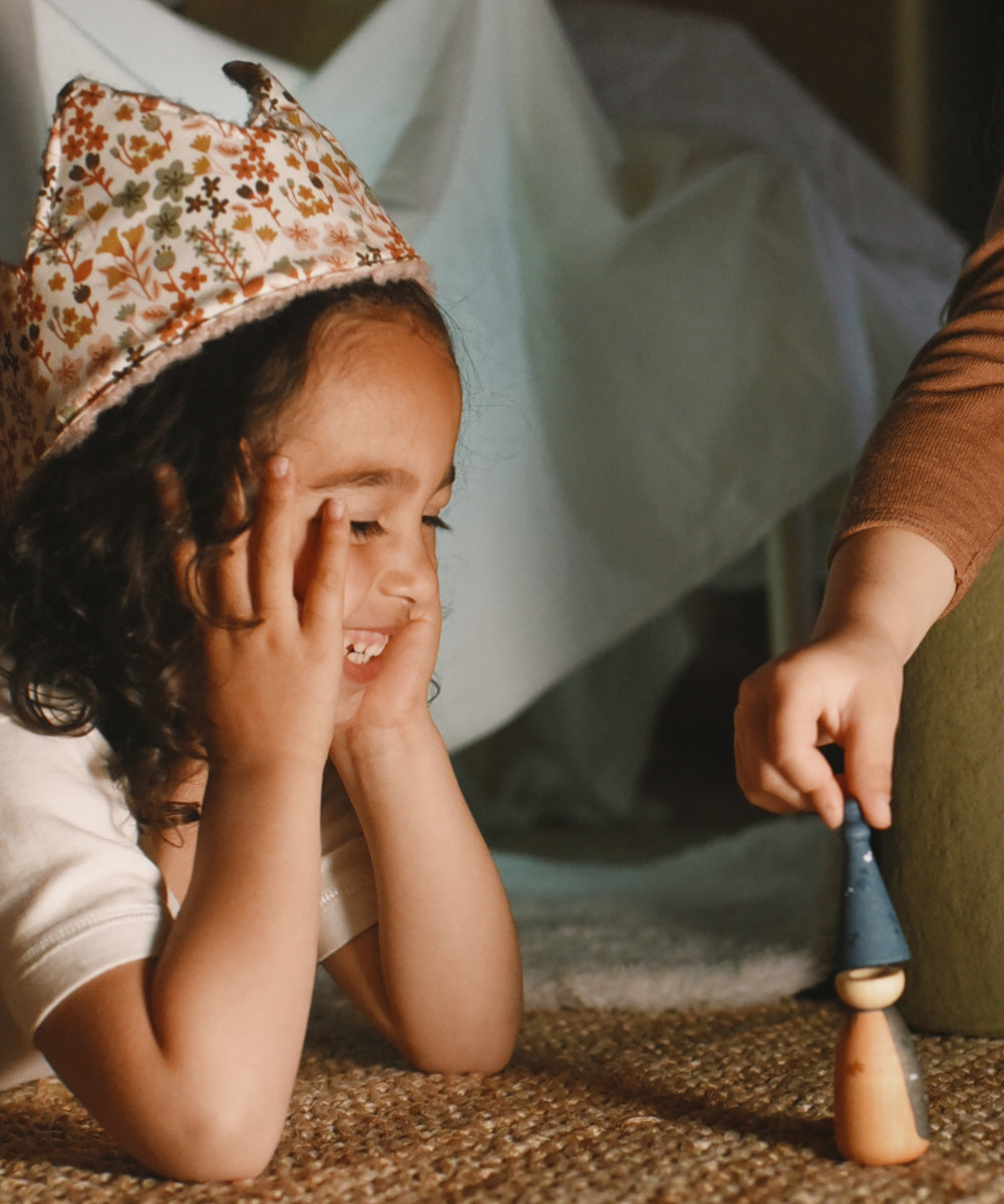 A child playing with the handmade and hand painted wooden nin peg doll from the Grapat advent calendar 2025 available at Babipur.