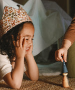A child playing with the handmade and hand painted wooden nin peg doll from the Grapat advent calendar 2025 available at Babipur.