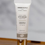 The Green People, natural and organic soothing eye serum is stood on a small wooden table with a grey background